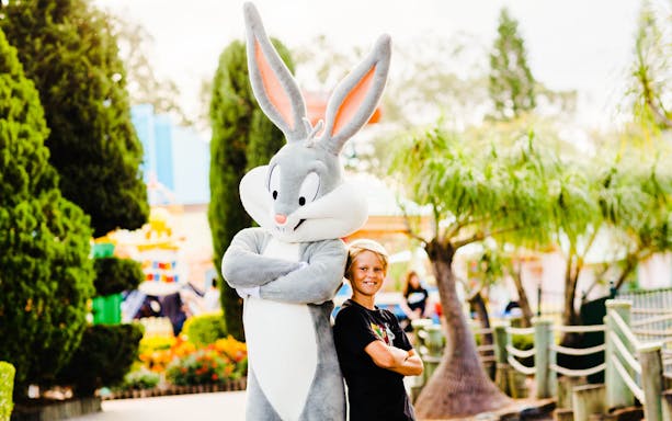 Boy posing with Bugs Bunny character at Warner Brothers Movie World.