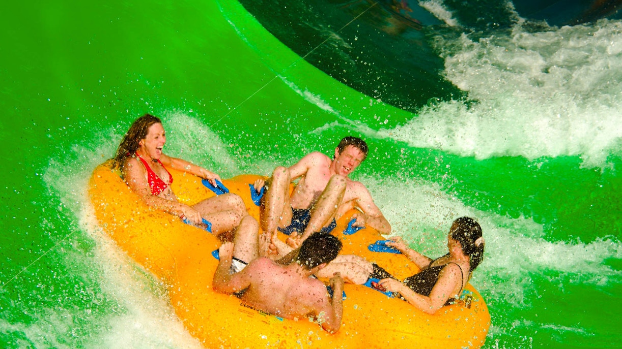 Water slides and wave pool at Wet 'n' Wild, Gold Coast, Australia, with visitors enjoying a sunny day.