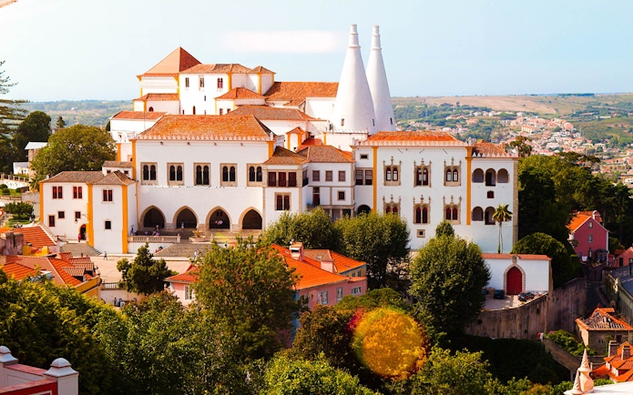 National Palace of Sintra with iconic chimneys and surrounding landscape.