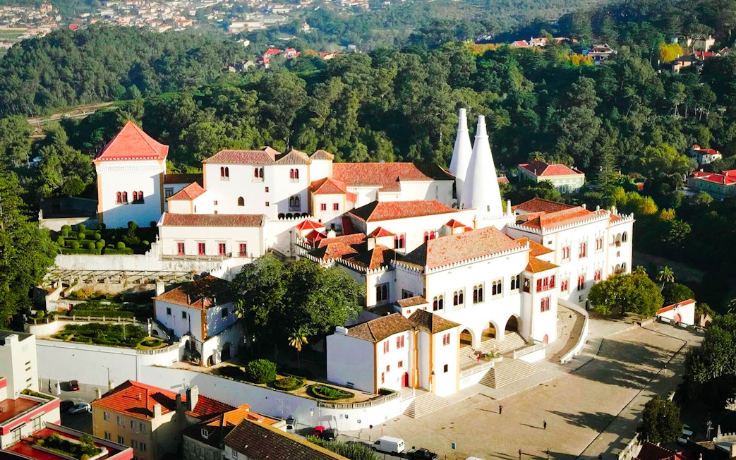 National Palace of Sintra with iconic chimneys and surrounding gardens.