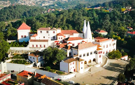National Palace of Sintra with iconic chimneys and surrounding gardens.