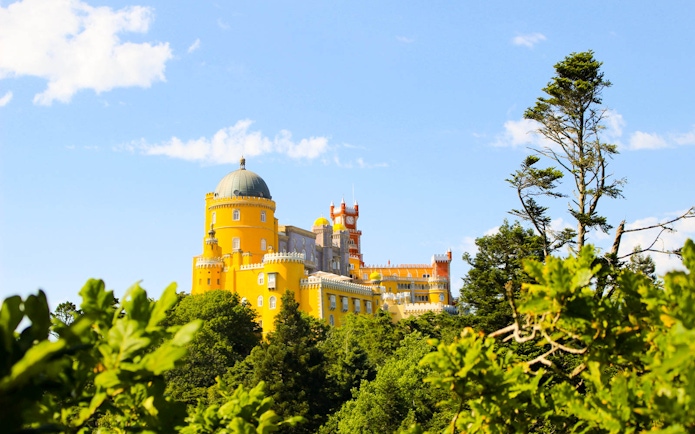 National Palace of Pena in Sintra, Portugal, with vibrant architecture surrounded by lush greenery.