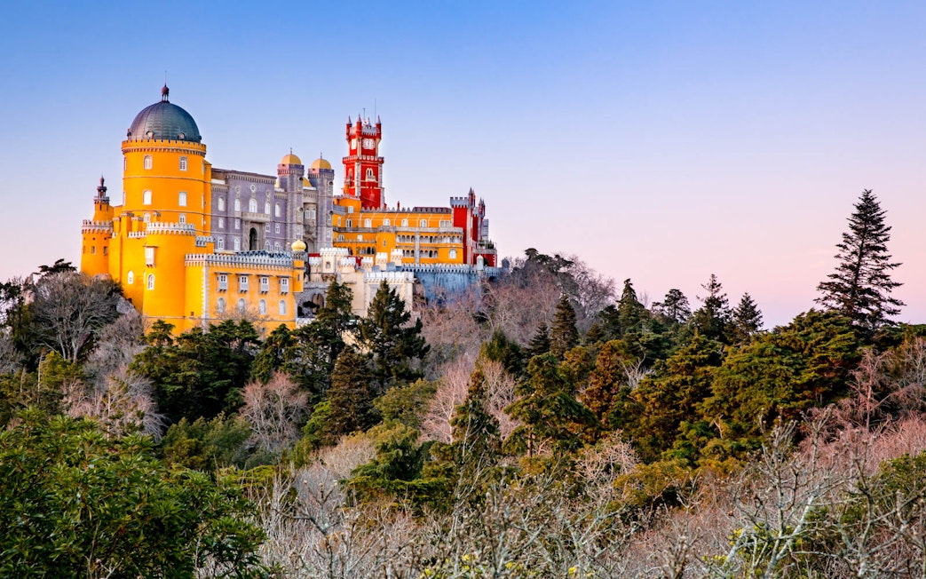 National Palace of Pena in Sintra, Portugal, with colorful architecture and surrounding forest.