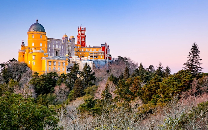 National Palace of Pena in Sintra, Portugal, with colorful architecture and surrounding forest.