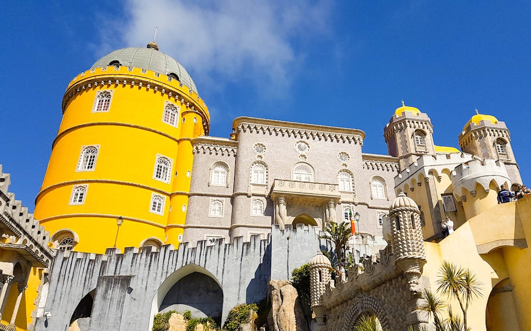 National Palace of Pena in Sintra with vibrant yellow towers and intricate architecture.