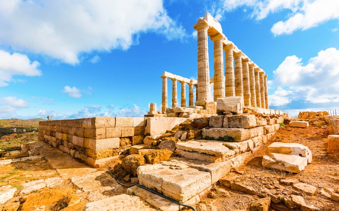 Temple of Poseidon ruins at Cape Sounion under a blue sky, part of guided tour from Athens.