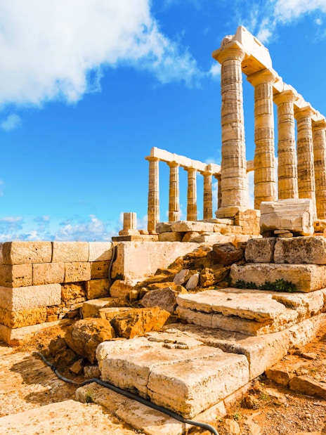 Temple of Poseidon ruins at Cape Sounion under a blue sky, part of guided tour from Athens.
