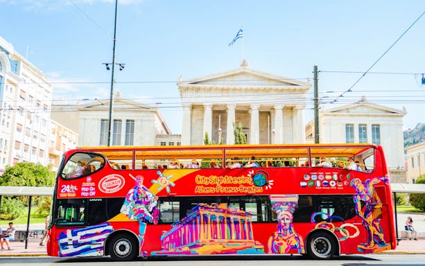Open-top sightseeing bus in front of the National Library of Greece, Athens.