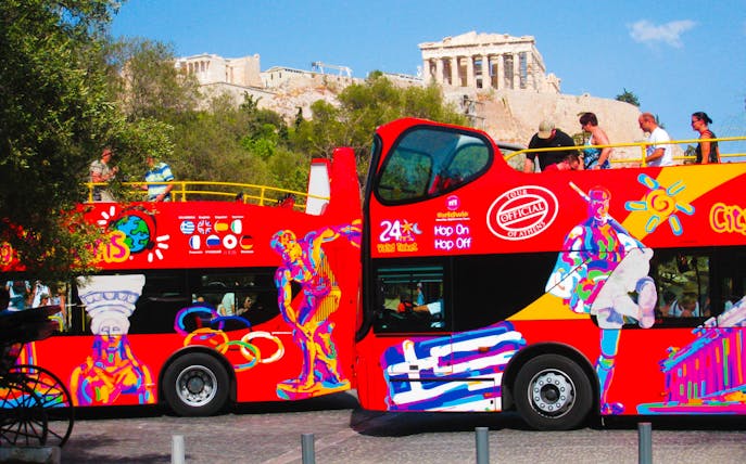 Athens hop-on-hop-off bus with Acropolis in the background.