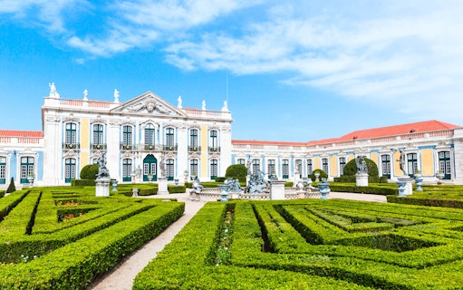 National Palace of Queluz with manicured gardens and statues in Portugal.
