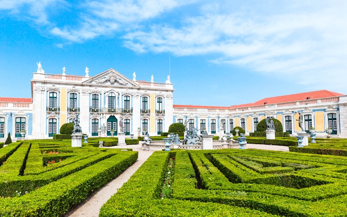 National Palace of Queluz with manicured gardens and statues in Portugal.