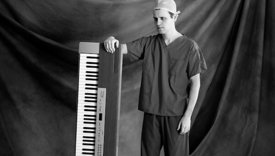 Man in scrubs with a keyboard, related to "Adam Kay: This Is Going to Hurt" tour.
