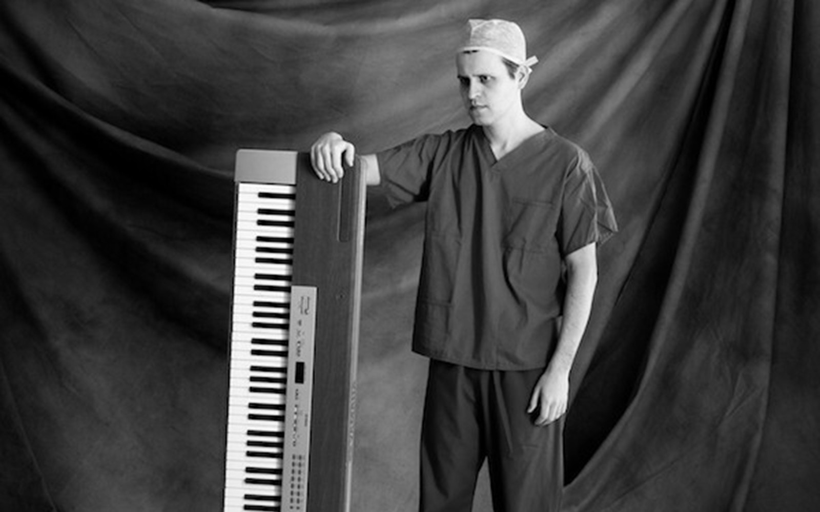 Man in scrubs with a keyboard, related to "Adam Kay: This Is Going to Hurt" tour.
