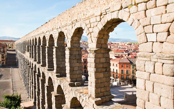 Segovia Roman aqueduct with cityscape in the background.