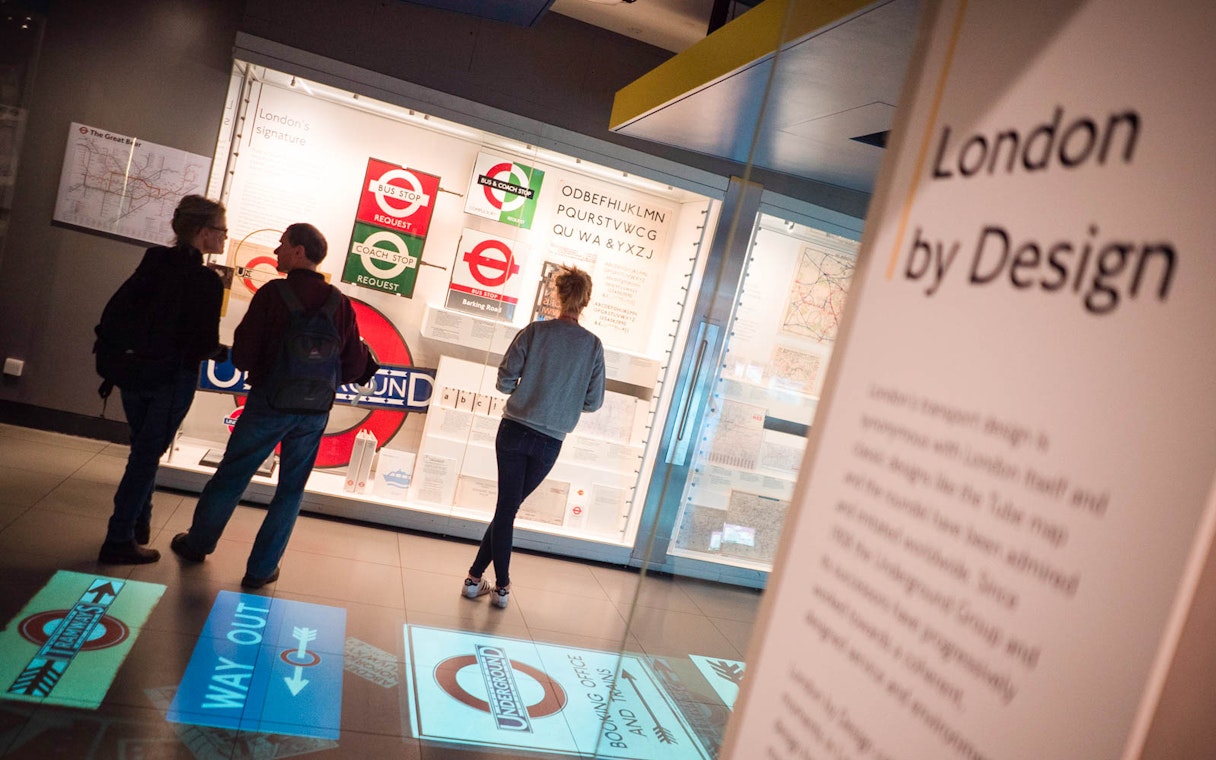 Visitors viewing London Transport Museum exhibit on Underground design.