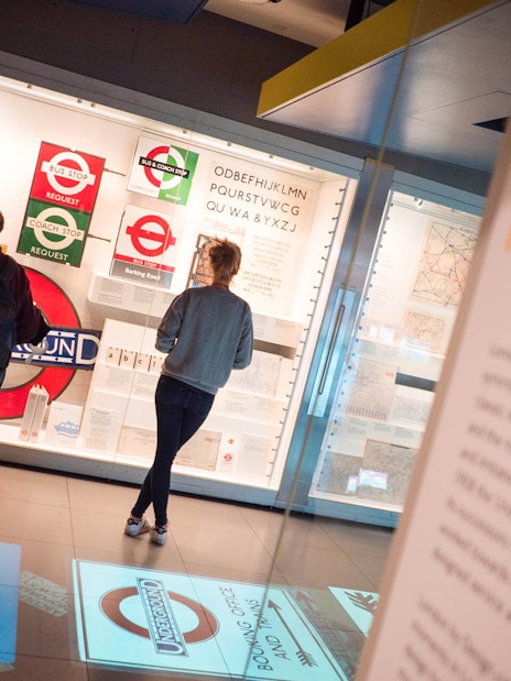 Visitors viewing London Transport Museum exhibit on Underground design.
