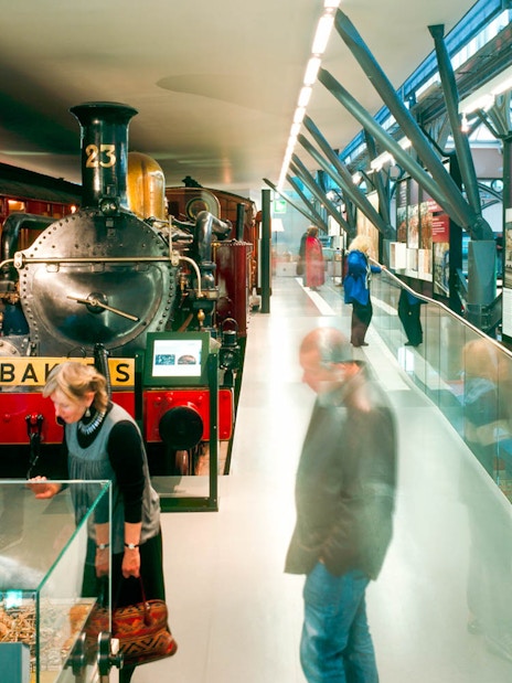 Steam locomotive exhibit at London Transport Museum with visitors exploring displays.