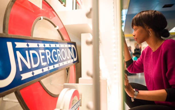 Person examining London Underground sign at London Transport Museum.