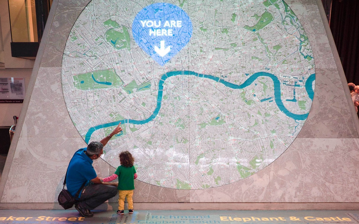 Man and child looking at large map display at London Transport Museum.