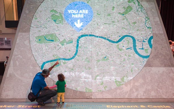 Man and child looking at large map display at London Transport Museum.