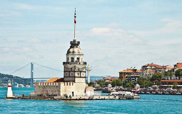 Maiden's Tower on Bosphorus with cityscape and bridge in Istanbul.