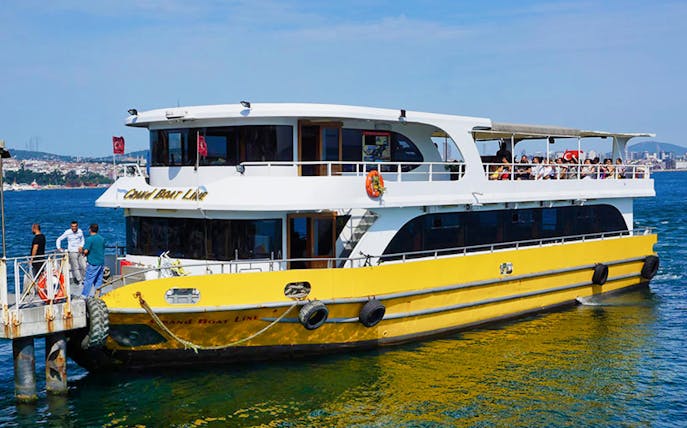 Boat docked for 2-hour Bosphorus tour, Istanbul, with passengers on deck.