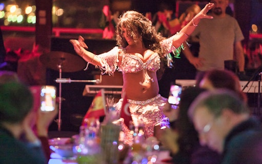 Belly dancer performing on Bosphorus dinner cruise with live audience.