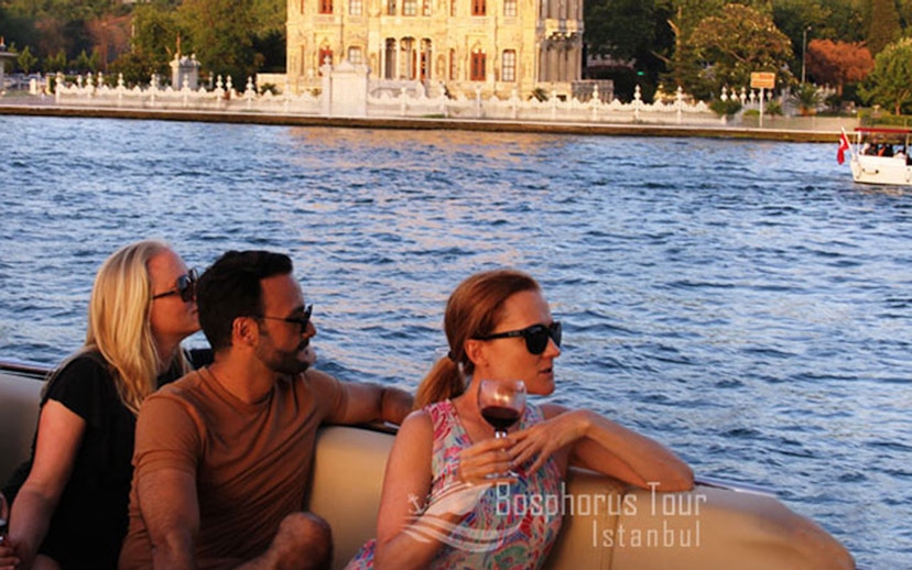 Tourists enjoying a Bosphorus cruise with a view of Istanbul's waterfront architecture.