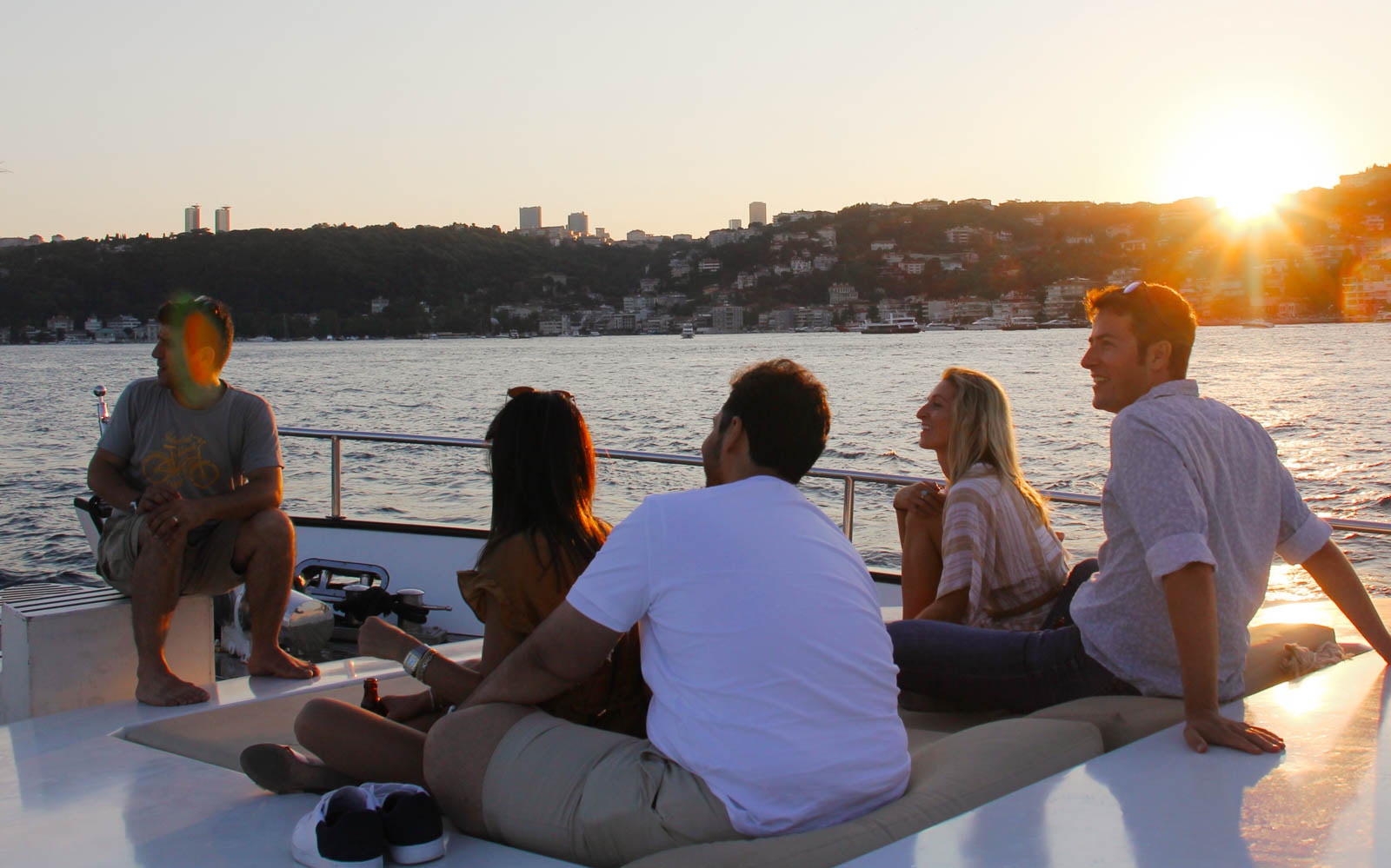 Bosphorus yacht cruise at sunset with guests enjoying drinks and canapés, Istanbul, Turkey.