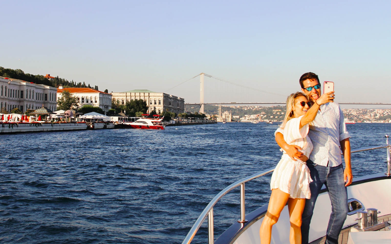 Bosphorus yacht cruise at sunset with drinks and canapes, Istanbul skyline in the background.