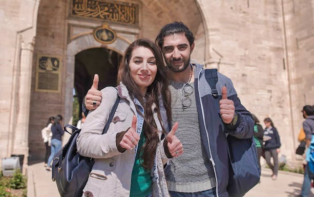 Visitors giving thumbs up at the entrance of Topkapi Palace, Istanbul.