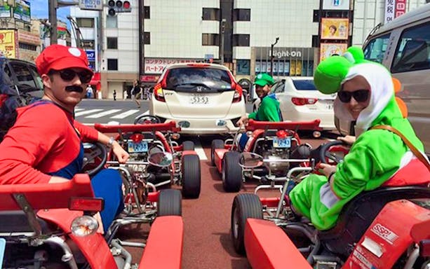 Go-kart riders in costume on Tokyo street during Akihabara tour.