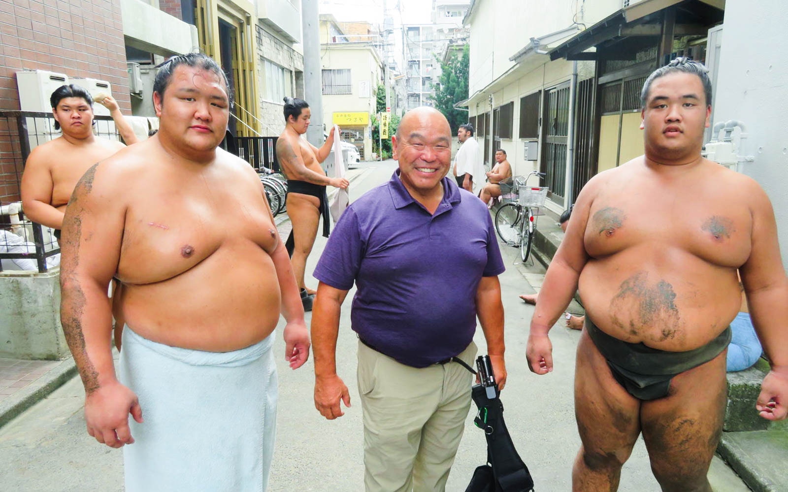 Sumo wrestlers and a visitor at a sumo stable in Tokyo during morning practice.