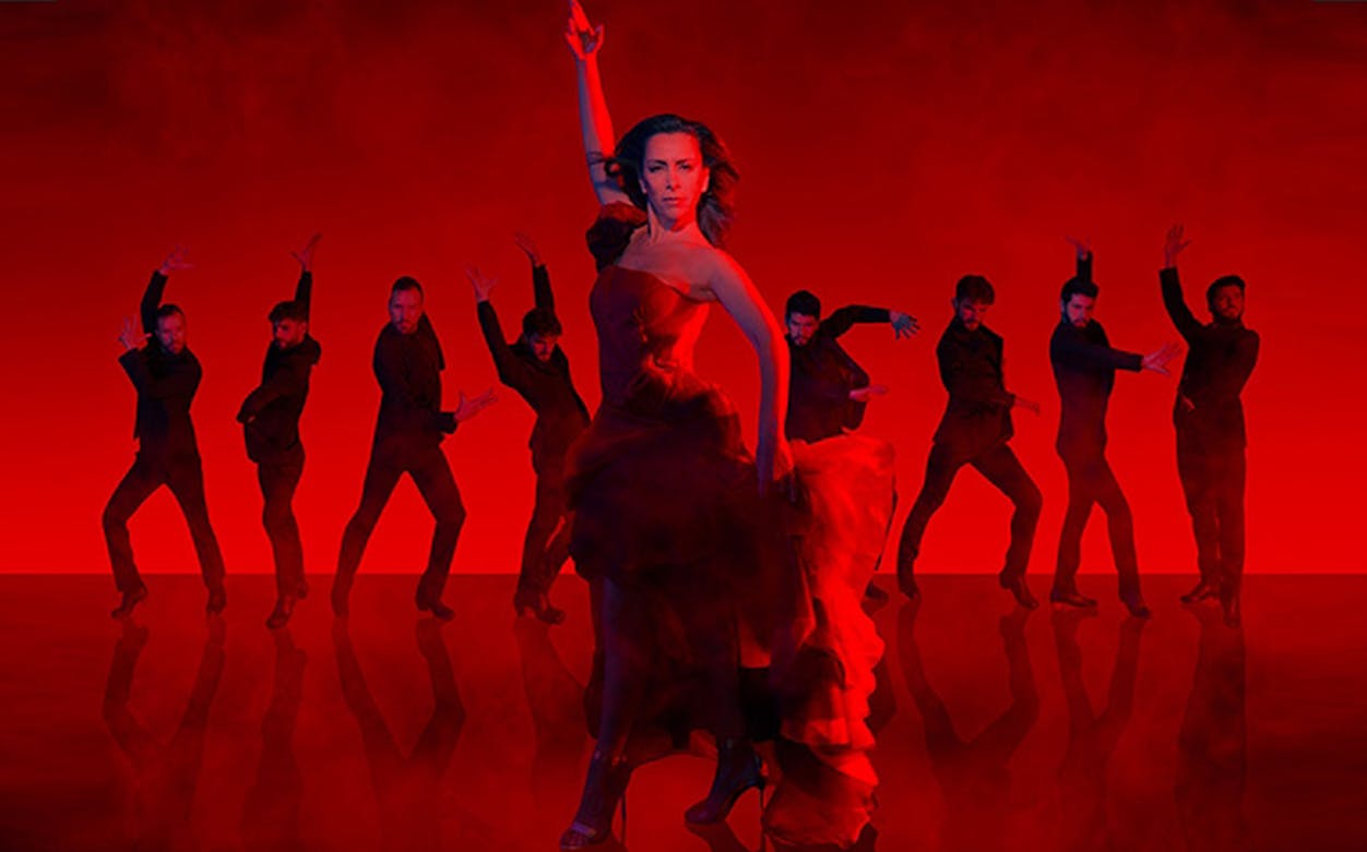 Flamenka dancers performing in a dramatic red-lit setting.