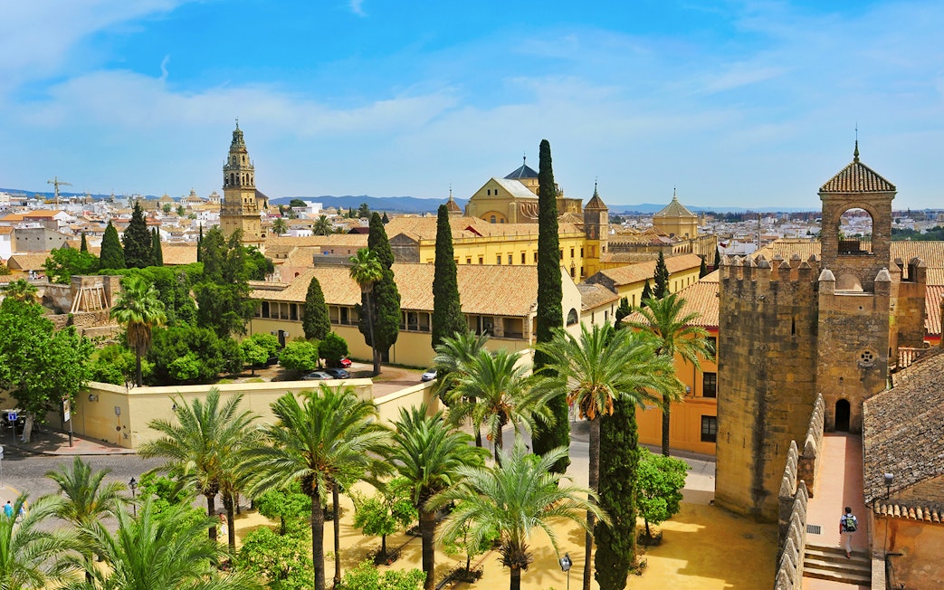 Alcazar of Cordoba with gardens and historic architecture under a clear sky.