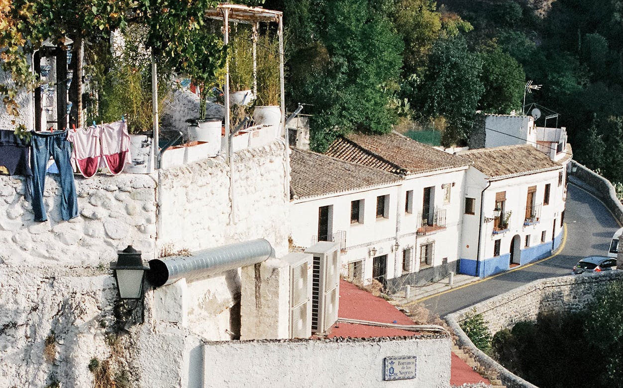 Albaicin street view with traditional Moorish houses and stone walls in Granada, Spain.