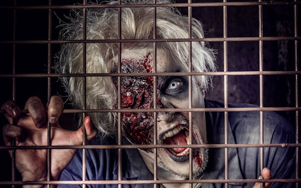 Zombie actor behind bars at The London Bridge Experience.