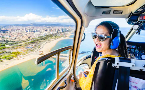 Helicopter view of Barcelona coastline with passenger enjoying the 360º SkyWalk experience.