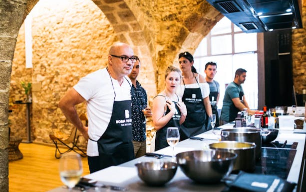 Local chef demonstrating paella cooking in Barcelona kitchen.