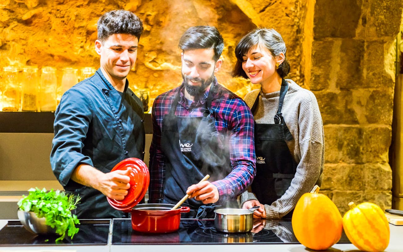 Local chef teaching tourists how to cook traditional Paella in a Barcelona cooking class