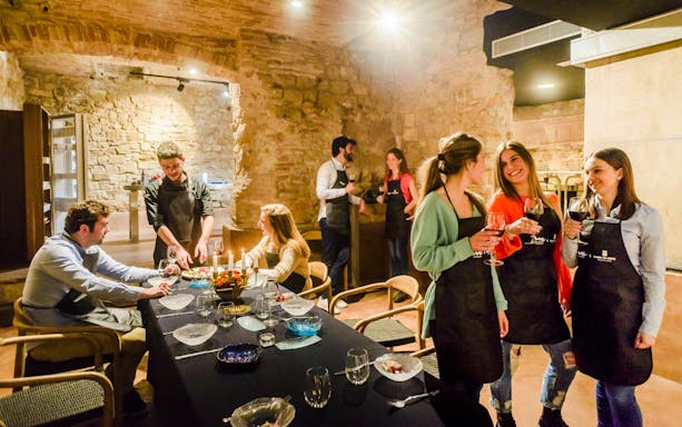 Chef preparing tapas at a cooking show in Barcelona with cocktails on the table.