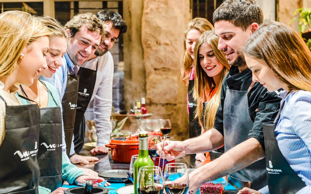 Chef preparing tapas at a cooking show in Barcelona with cocktails on display.