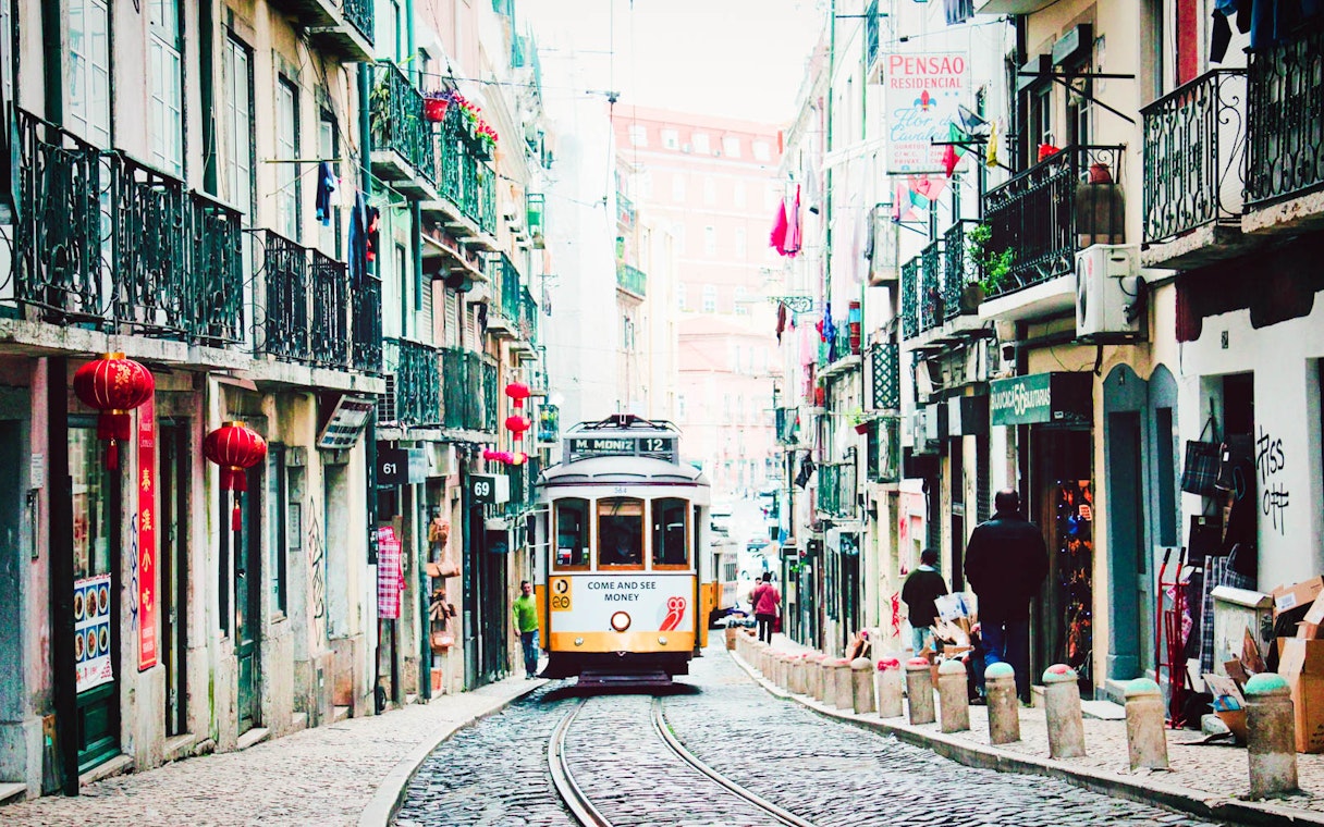 Lisbon tram on a narrow street, part of the Lisbon Card and Hop-On Hop-Off Bus Tour.