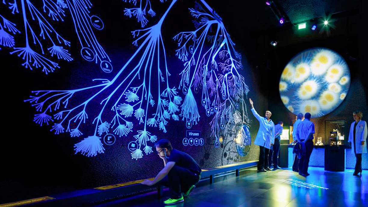 Interactive exhibit at Micropia Amsterdam with visitors exploring microorganisms.