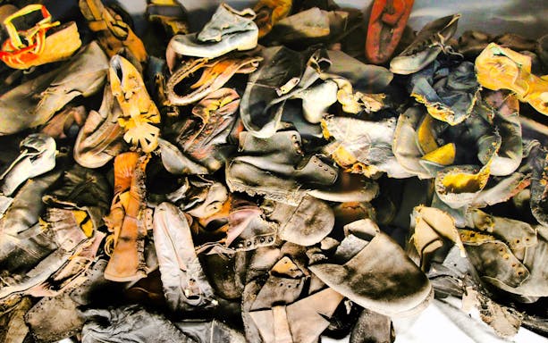 Piles of worn shoes at Auschwitz-Birkenau Museum exhibit.
