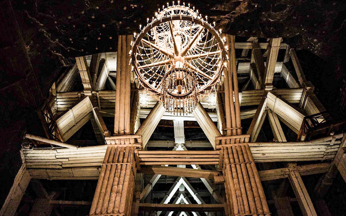 Chandelier in Wieliczka Salt Mine's wooden structure during guided tour.