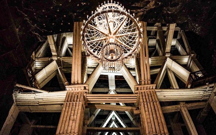 Chandelier in Wieliczka Salt Mine's wooden structure during guided tour.