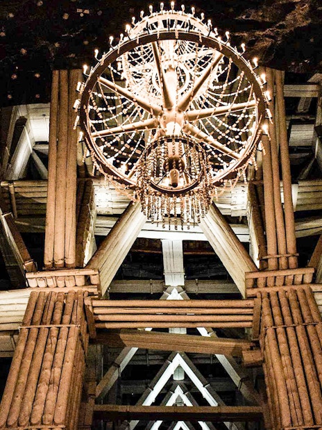 Chandelier in Wieliczka Salt Mine's wooden structure during guided tour.