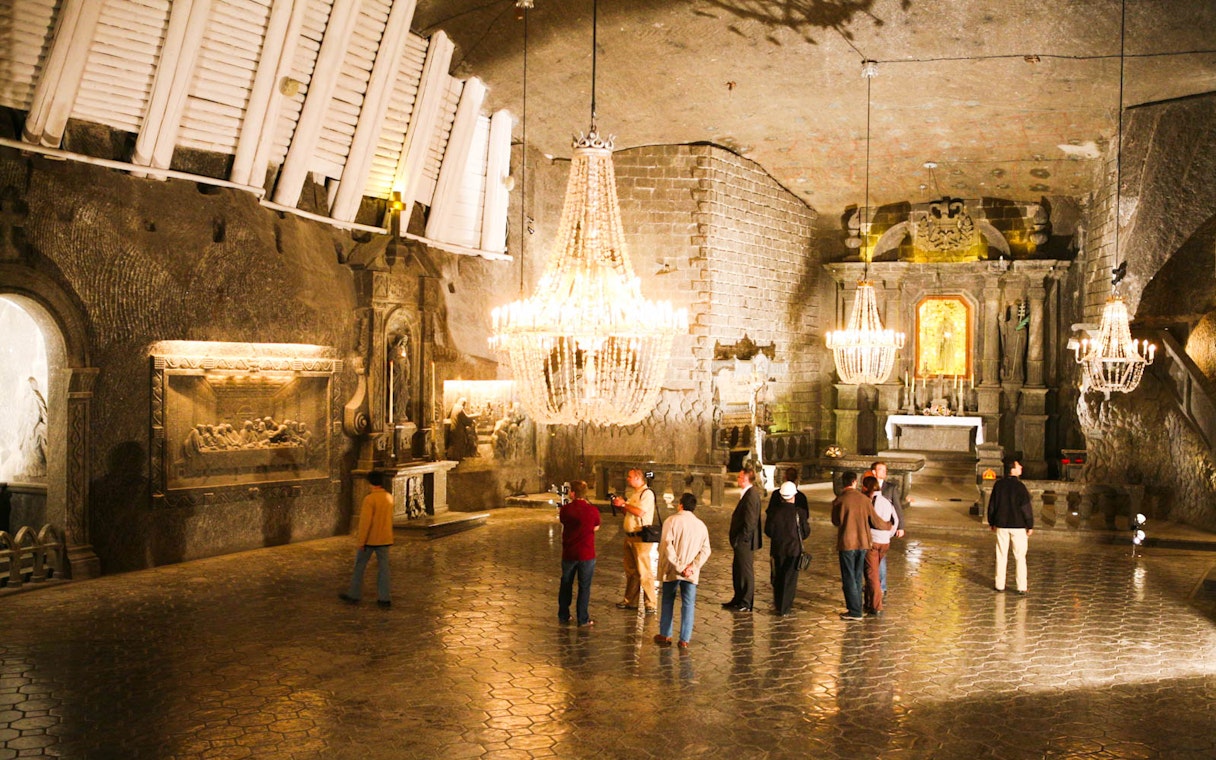Visitors exploring the ornate chapel inside Wieliczka Salt Mine on a guided tour.