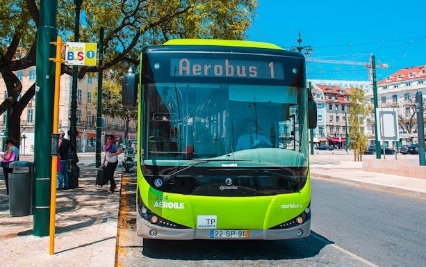 Aerobus Lisbon shuttle bus at a city stop with passengers nearby.